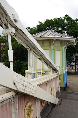 Photo of the colourful tollbooth with white bridge cables in the foreground.