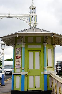 Photo of a small, octagonal tollbooth painted white with bright green and blue details.