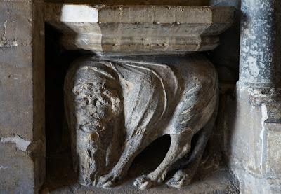 Photo of another, equally strange carving of an animal body with cloven hooves and a bearded human face.