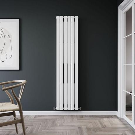 Milano Erin white vertical flat panel designer convector radiator on dark wall nearby white glass frame and framed art and wicker chair