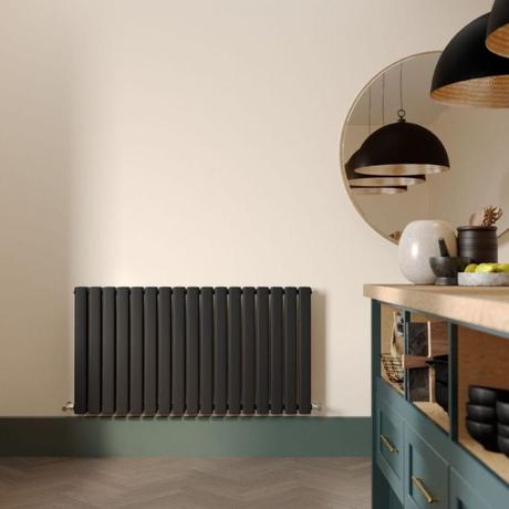 Milano Alpha black horizontal flat panel designer radiator on cream wall nearby large mirror and modern countertop