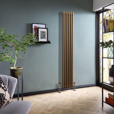 8 radiator ideas for period properties Milano Windsor metallic bronze vertical traditional double column radiator on light blue wall in modern home nearby framed art and houseplant and gray chair