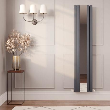 8 radiator ideas for period properties Milano Icon anthracite vertical mirrored designer radiator on cream wall nearby triple light fitting above small table with gold vase and artificial houseplant