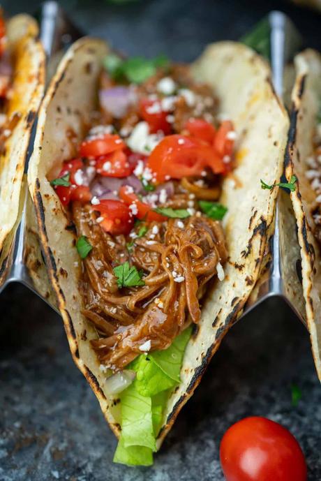Shredded Beef Tacos assembled shredded beef tacos with tomatoes, herbs, and cheese