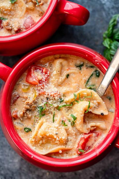Creamy Tortellini Soup a red bowl of creamy tortellini soup with basil on top