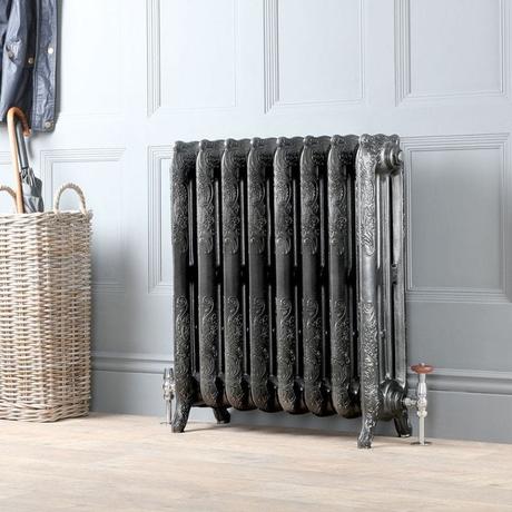 Milano Beatrix dark pewter ornate cast iron radiator in front of gray wall on light wooden flooring