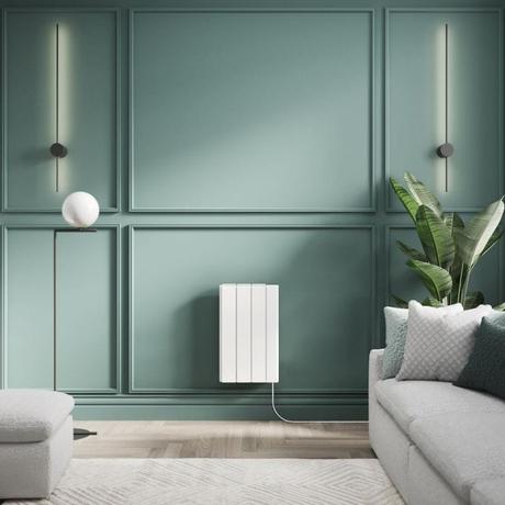 ECOSO Tuc white ceramic core smart electric heater on green wall nearby houseplant and light gray settee