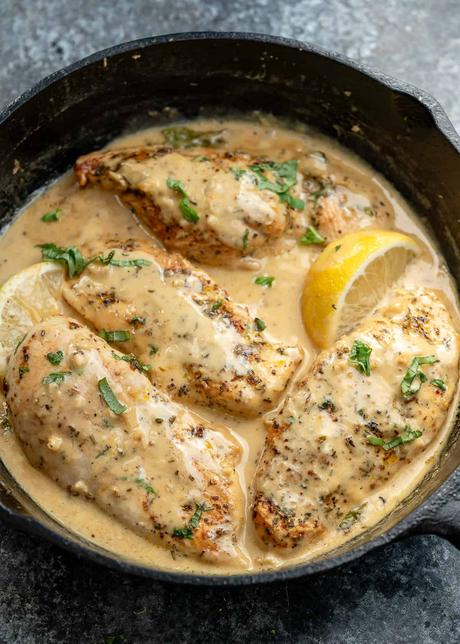 overhead image of a cast iron skillet with cooked lemon chicken