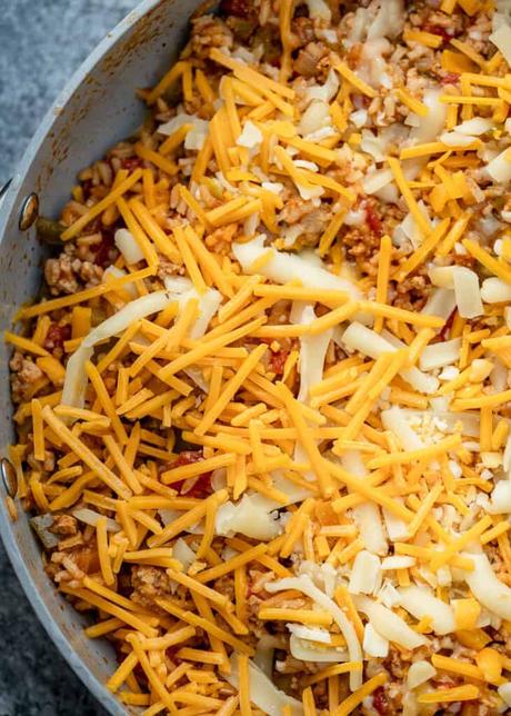 shredded cheese on top of a beef and rice mixture