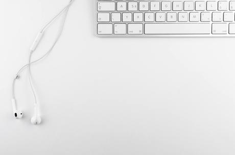 A pristine white desk scene featuring an open laptop displaying colorful ecommer