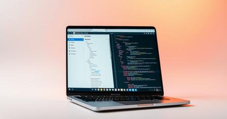 A sleek MacBook Pro displaying WordPress admin dashboard with the Code Snippets 