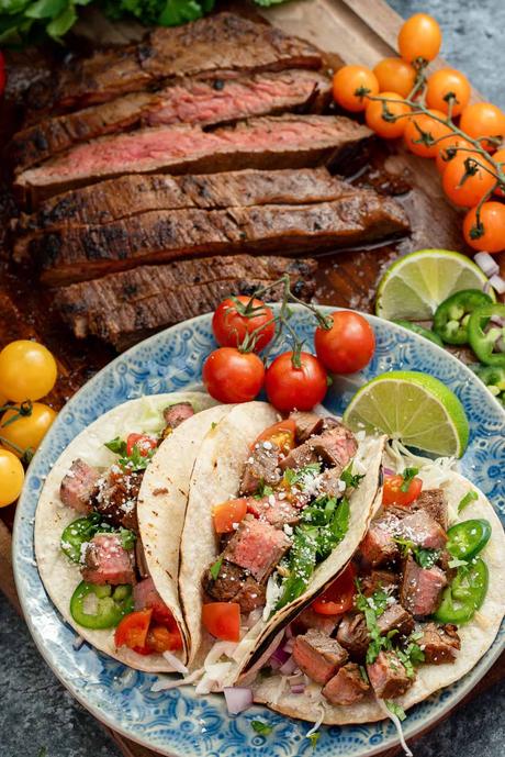 Carne Asada Tacos overhead image of a plateful of carne asada tacos with sliced carne asada in the background