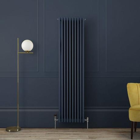 Milano Windsor regal blue vertical traditional 3 column radiator on dark wall nearby freestanding light fitting and yellow chair