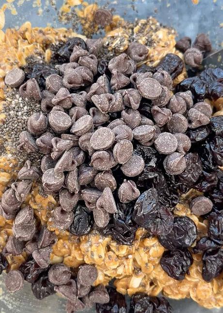 Dark Chocolate Cherry Granola Bars chocolate chips and dried cherries being added to homemade granola bar mix