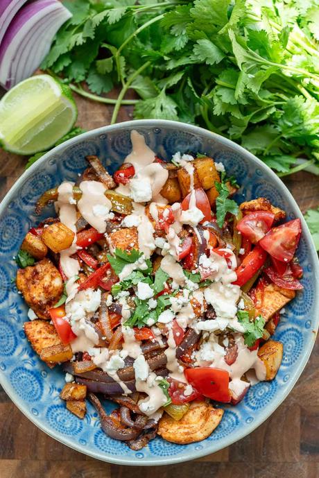 an overhead shot of a fiesta potato bowl with chipotle crema with cilantro and lime on the side