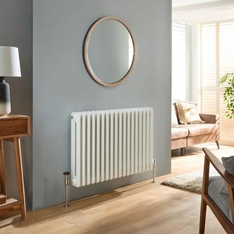 Milano Atticus white modern horizontal column radiator on light gray wall beneath round mirror