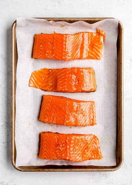 raw, marinated salmon filets on a sheet pan
