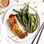 overhead image of baked salmon with teriyaki glaze on a white plate with green beans