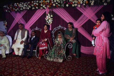 Muslim couple seated on elevated platform after wedding