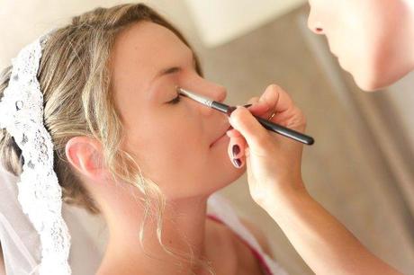 Bride getting her makeup professionally applied