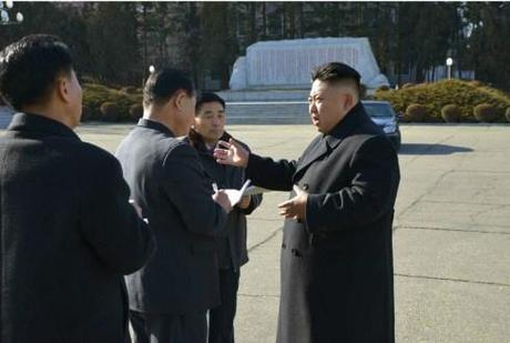 Kim Jong Un talks with DPRK officials in front of an autograph monument at Pyongyang Weak Current Apparatus Factory (Photo: Rodong Sinmun).
