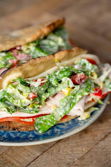 tangy grinder salad stuffed inside gluten-free sandwich bread with deli meat and provolone for grinder sandwiches