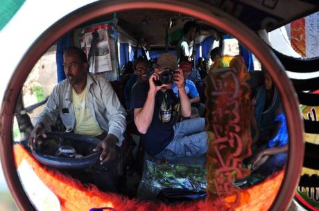 Bus journey in Ethiopia with interior of the bus, driver and passengers reflected in the driver’s mirror