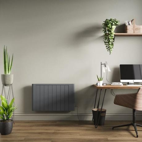 ECOSO Torr anthracite dry heat smart electric heater on wall in home office nearby desk with laptop beneath shelf with houseplant