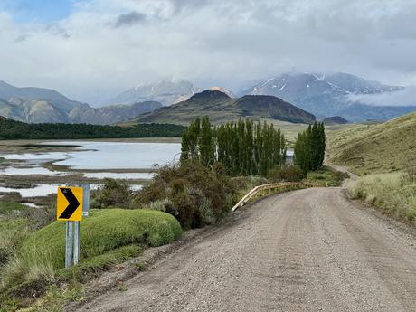 Gravel road crossing wetlands beneath cloud-covered mountains in Parque Nacional Patagonia in southern Chile