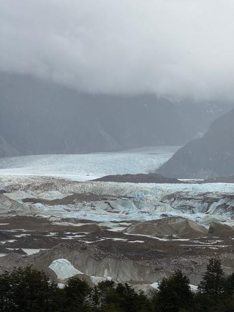 Crevassed Exploradores Glacier and dark moraine beneath low cloud in the mountains of Chilean Patagonia along the Carretera Austral route