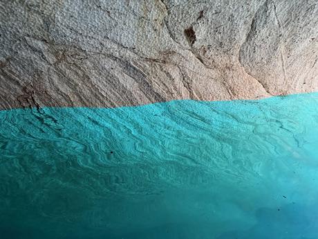 Turquoise water reflecting the textured rock walls inside the Marble Caves on Lago General Carrera, Chilean Patagonia