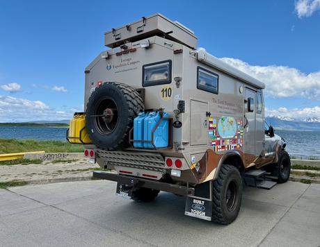 Overland expedition camper parked beside the waterfront in Puerto Natales with mountains across the water