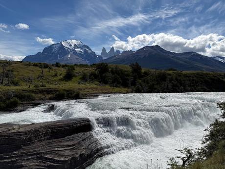 Cascada Río Paine flowing over a broad rocky ledge beneath snow-capped mountains in Torres del Paine National Park