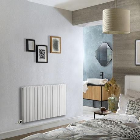 Milano Capri electric white horizontal designer radiator on white wall beneath three framed pictures adjacent to wall with vanity unit and sink below diamond-shaped mirror