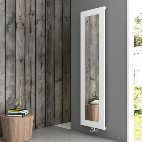 Carisa Quadro aluminum vertical designer radiator with mirror on gray wall nearby wooden panelling and outdoor setting