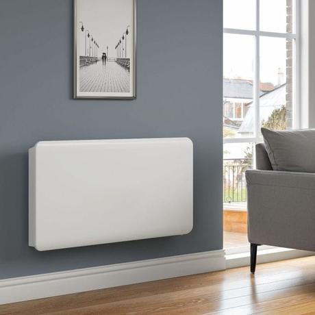 Reina Odet white plug-in electric ceramic core wifi radiator on gray wall beneath framed picture nearby gray settee
