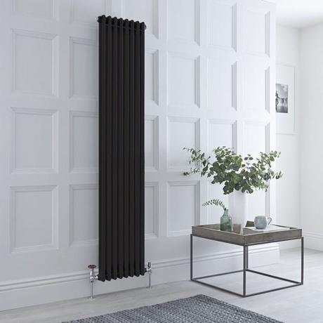 Milano Windsor black vertical traditional column radiator on white wall nearby small table with white vase