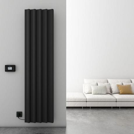 Carisa Boreas S black aluminum electric vertical designer radiator on light wall nearby digital thermostat and white low-level settee with cushions