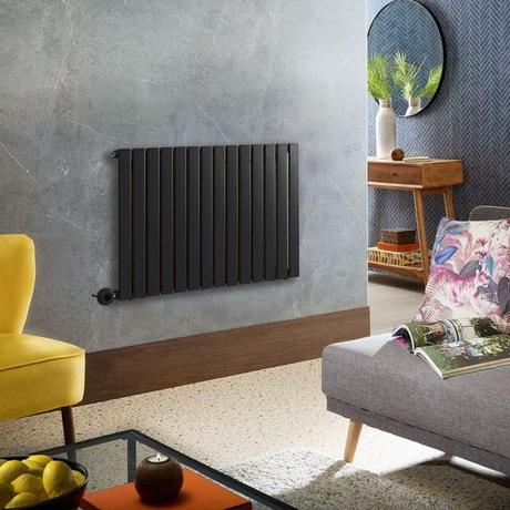 Milano Alpha black electric horizontal designer radiator on blue/grey wall above wooden skirting board