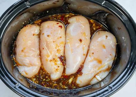 uncooked chicken in a slow cooker for honey chipotle chicken