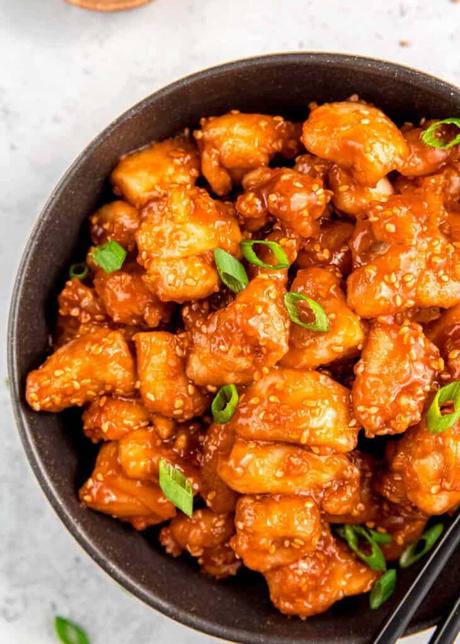 a bowl full of juicy sesame chicken