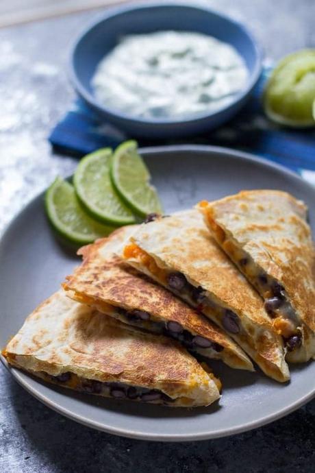 chipotle sweet potato black bean quesadillas on gray plate with lime slices