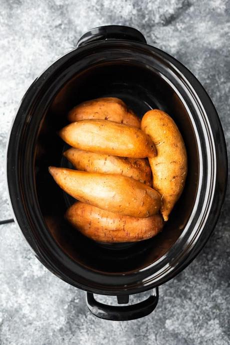 overhead shot of whole sweet potatoes in crock pot