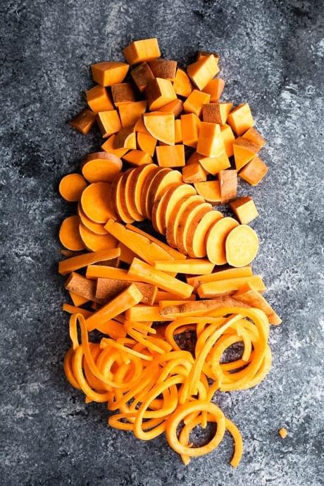 overhead shot of sweet potatoes cut in multiple ways on gray background