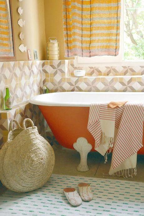 The tiles that cover the wall behind the bathtub are from an old factory in Villeneuve les Avignon. The bathtub is from the 19th century and was found on the internet and painted bright orange. #bathroom #orange #bathtub