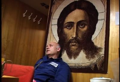 Christ in Russian sub. This commander is taking a break in the rec room for the crew, sitting beneath the print of a famous Orthodox icon of Christ. And, he's not in just any sub. He's in a Typhoon class, the kind written about in 