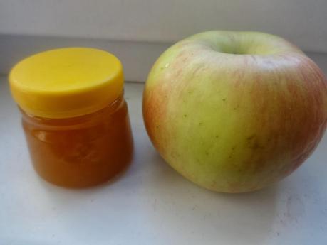 A jar of Honey and a green apple