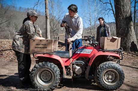 Clean Water Hub volunteers Kim Ellis (left) from Rock Creek, West Virginia and Casey Pegg (right) of Pittsburgh help Brett James tie down cases of water to his ATV at the group's Saturday water drop at the mouth of the hollow at Three Fork. Brett uses the water to drink, cook and bathe in. He says he hasn't even taken a bath in the municipal water provided by WV American Water since the 