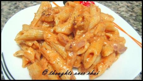 Pasta in a light red cream sauce with baby corn and shallots.