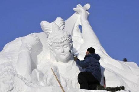 A worker shapes a snow sculpture prior to the Harbin International Ice and Snow Festival in Harbin